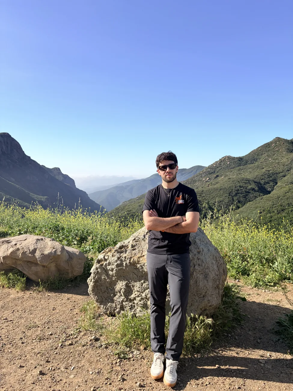 Shlomi standing on a rock with the Los Angeles mountains behind