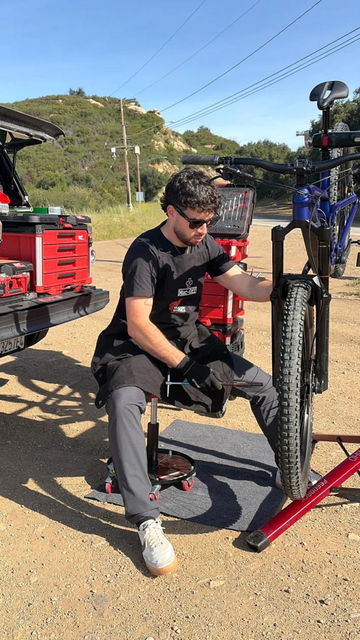Shlomi working from the mobile workshop stool beside the truck